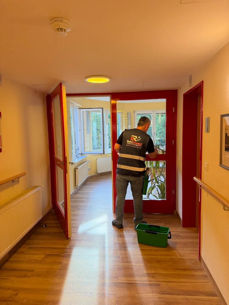 Reinigung einer verglasten Tür im Innenbereich.