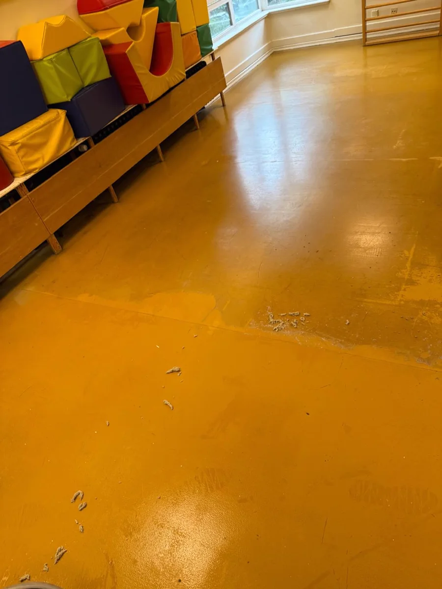 Gelber Boden im Bewegungsraum während der Bearbeitung mit gelösten Rückständen.